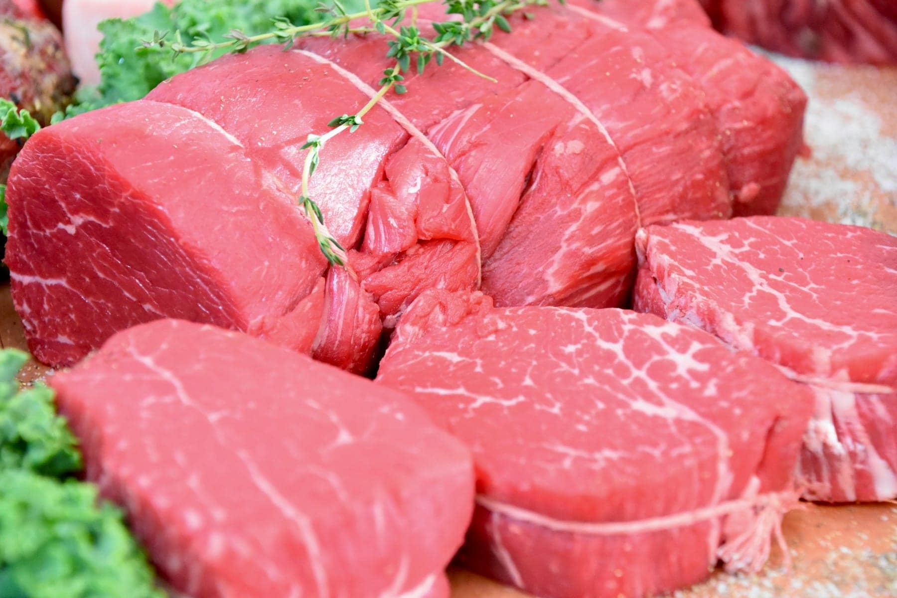 Rôtis et tournedos ficelés en gros plan sur l'étal d'une boucherie