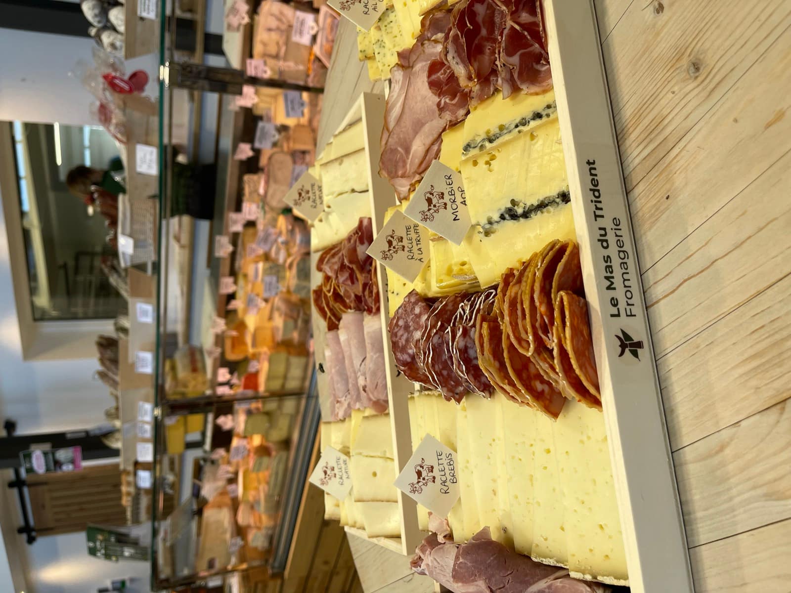 Plateau de raclettes préparé dans notre fromagerie, devant la vitrine à fromages