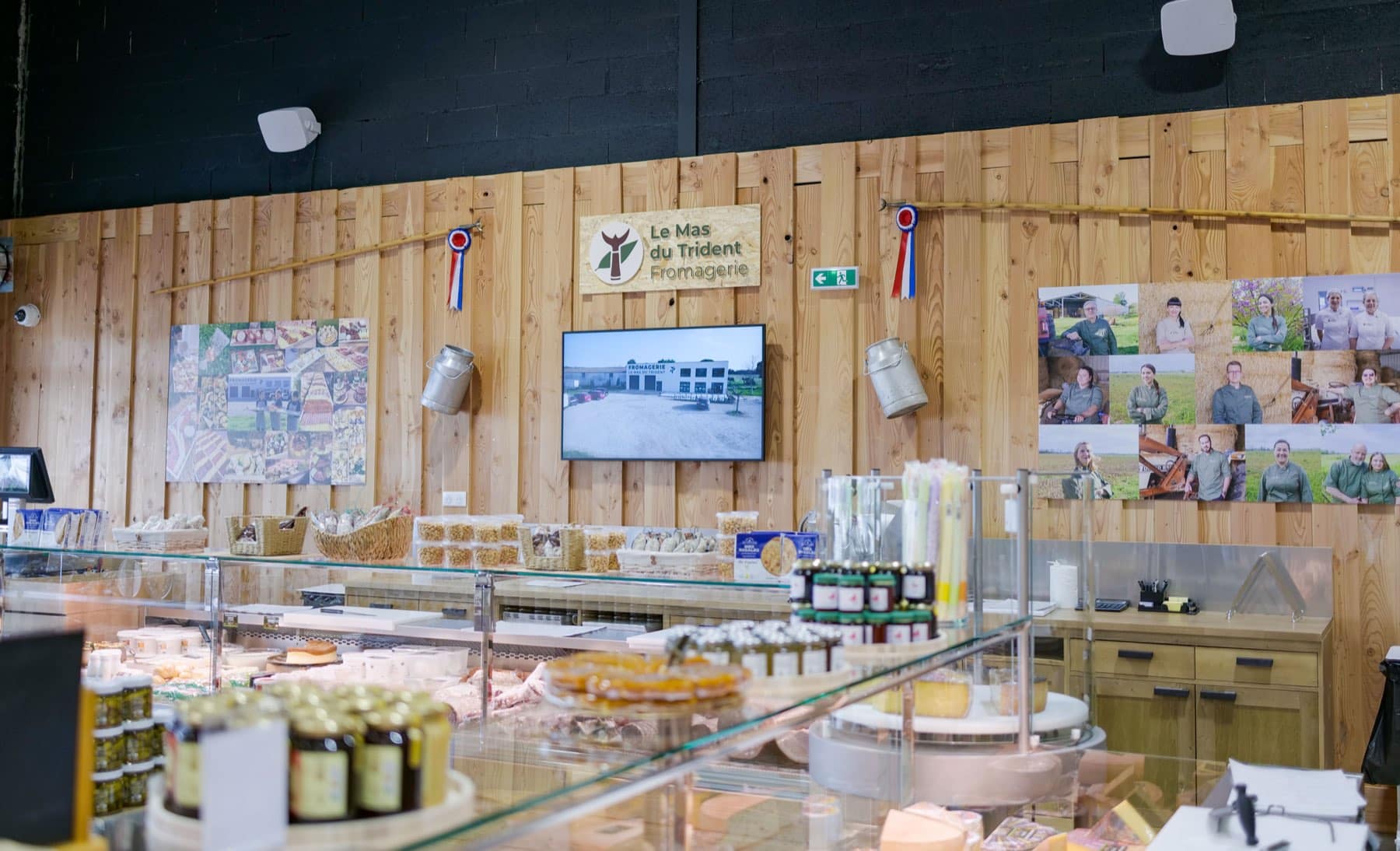 Le comptoir de notre boutique de Saint-Dionisy, avec le mur de photos de l'équipe et les cocardes de concours