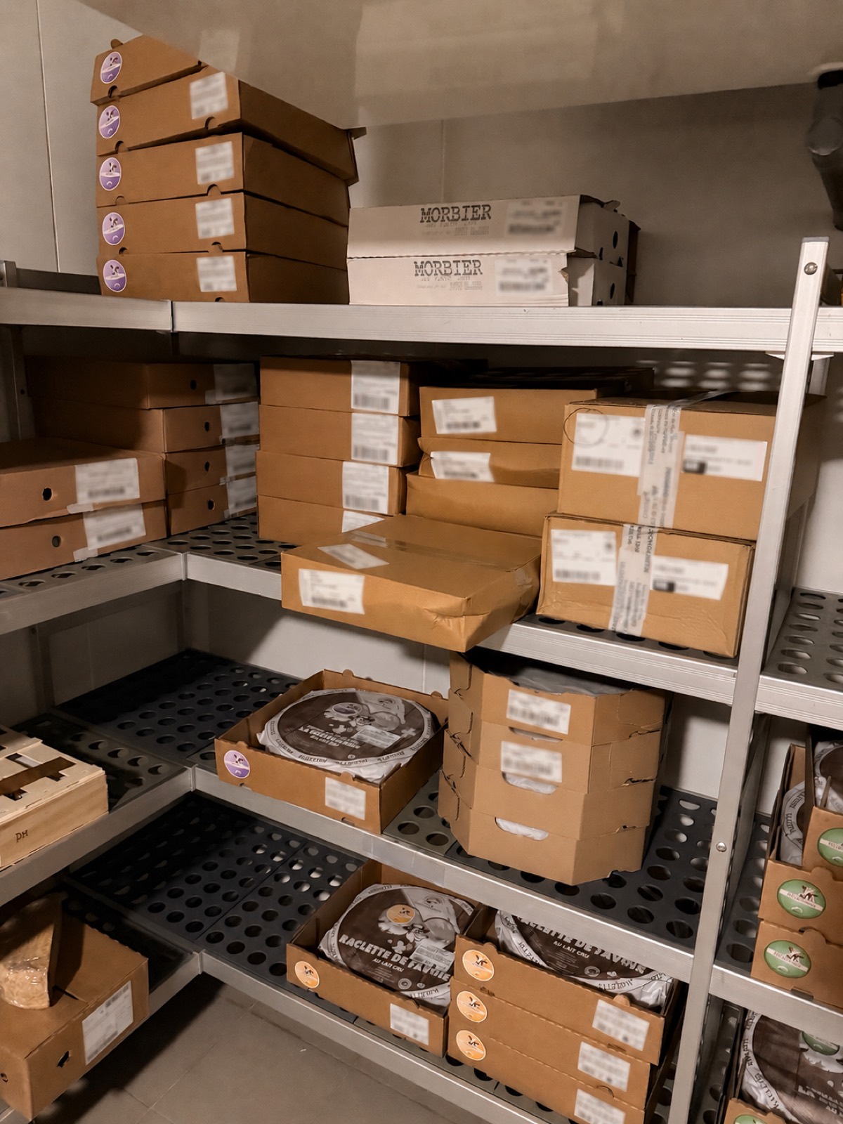 Cartons de fromages en stock sur les étagères d'une chambre froide